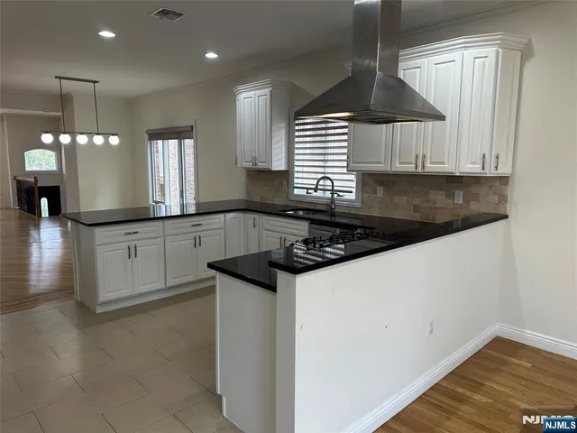 a kitchen with granite countertop a sink a stove and cabinets