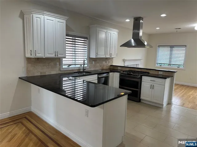 a kitchen with granite countertop a sink a stove and cabinets