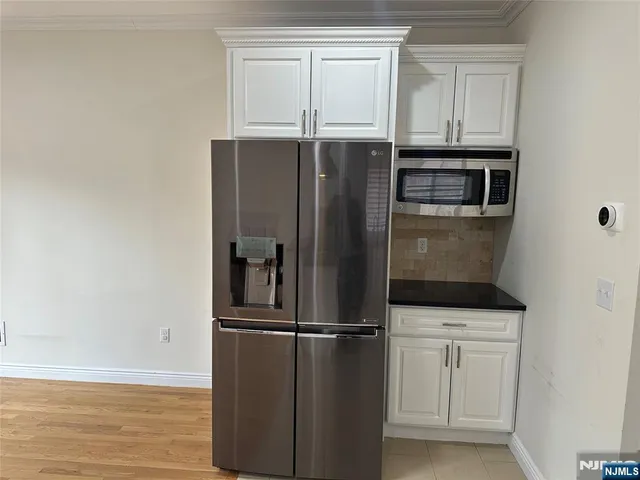 a kitchen with white cabinets and stainless steel appliances