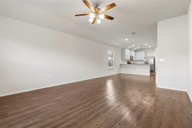 a view of an empty room and kitchen view