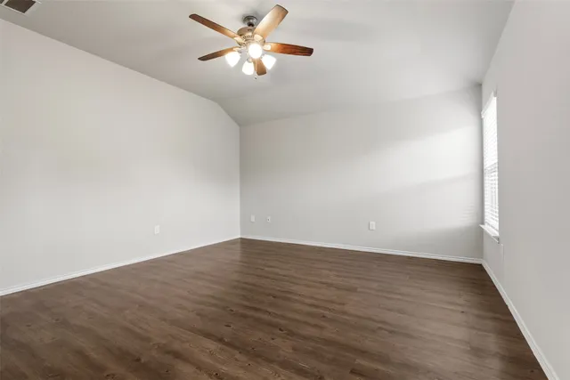 an empty room with wooden floor chandelier fan and closet area