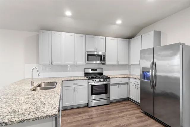 a kitchen with a refrigerator sink and cabinets