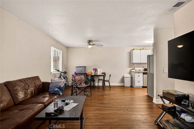 a kitchen with stainless steel appliances a stove top oven a sink a refrigerator and wooden floor