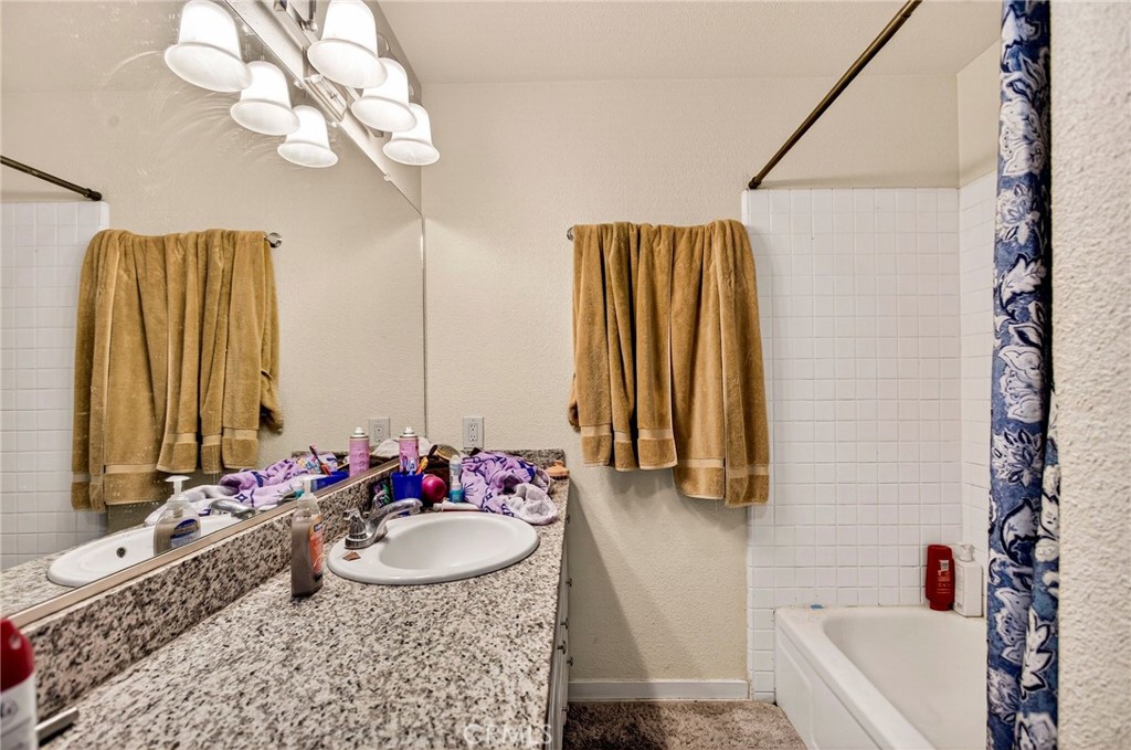 703 West 2nd Avenue Chico, CA 95926 - Photo 15 of 27 a bathroom with a granite countertop sink and a mirror