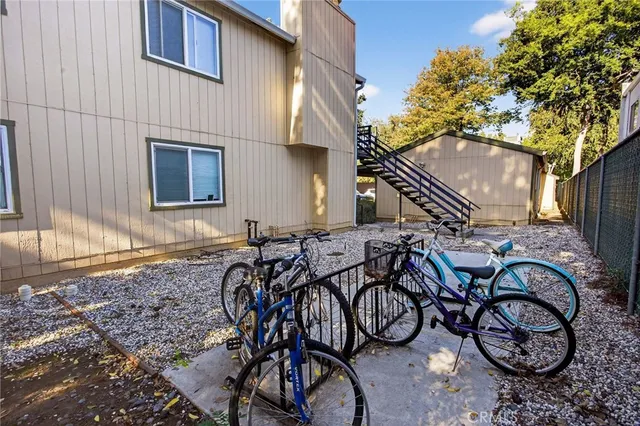 a kitchen with stainless steel appliances kitchen island granite countertop a refrigerator oven a sink dishwasher and white cabinets with wooden floor