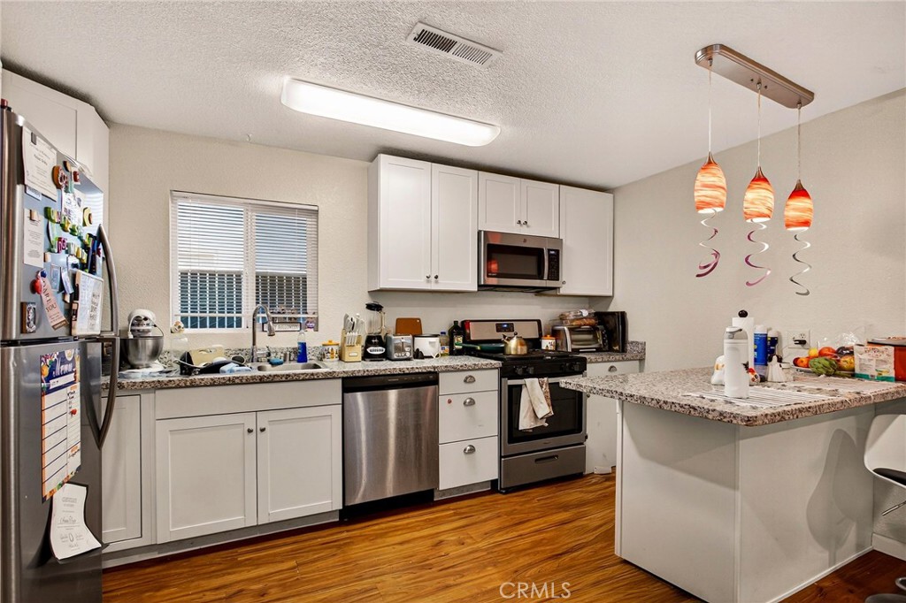 703 West 2nd Avenue Chico, CA 95926 - Photo 20 of 27 a kitchen with a sink stove and cabinets