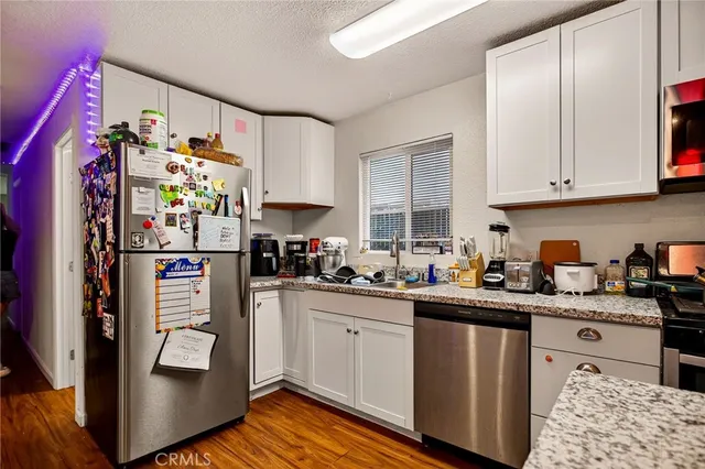 a kitchen with stainless steel appliances granite countertop a refrigerator and stove top oven