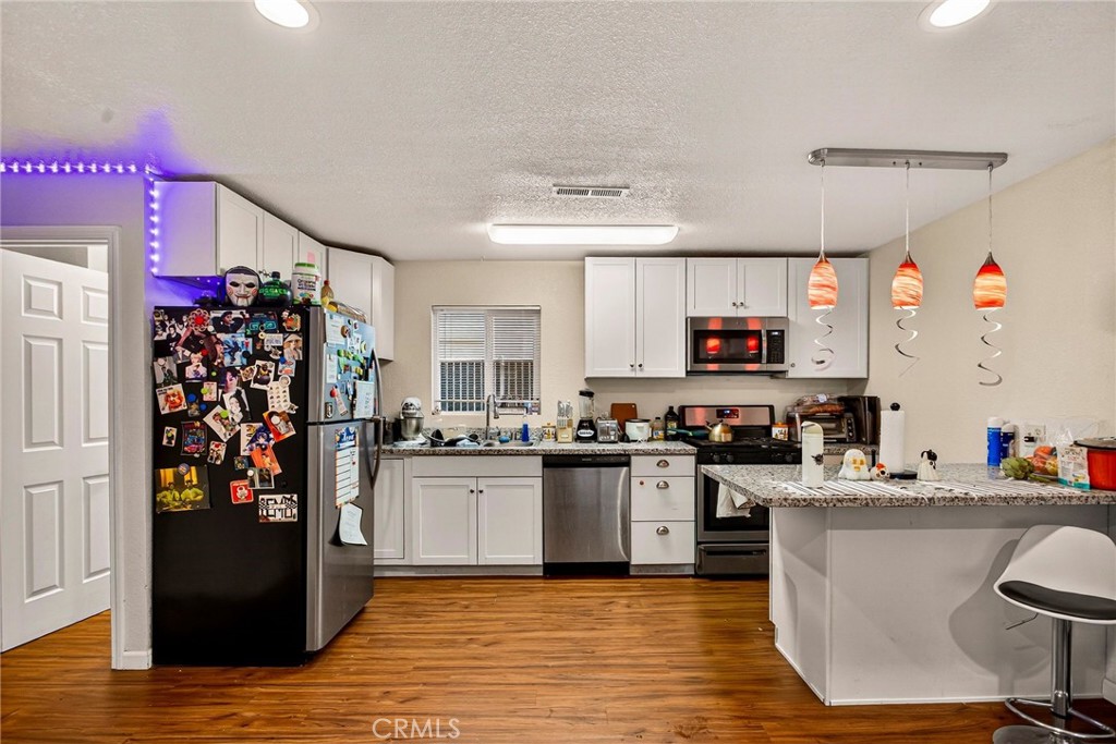 703 West 2nd Avenue Chico, CA 95926 - Photo 22 of 27 a kitchen with stainless steel appliances granite countertop a refrigerator and stove top oven