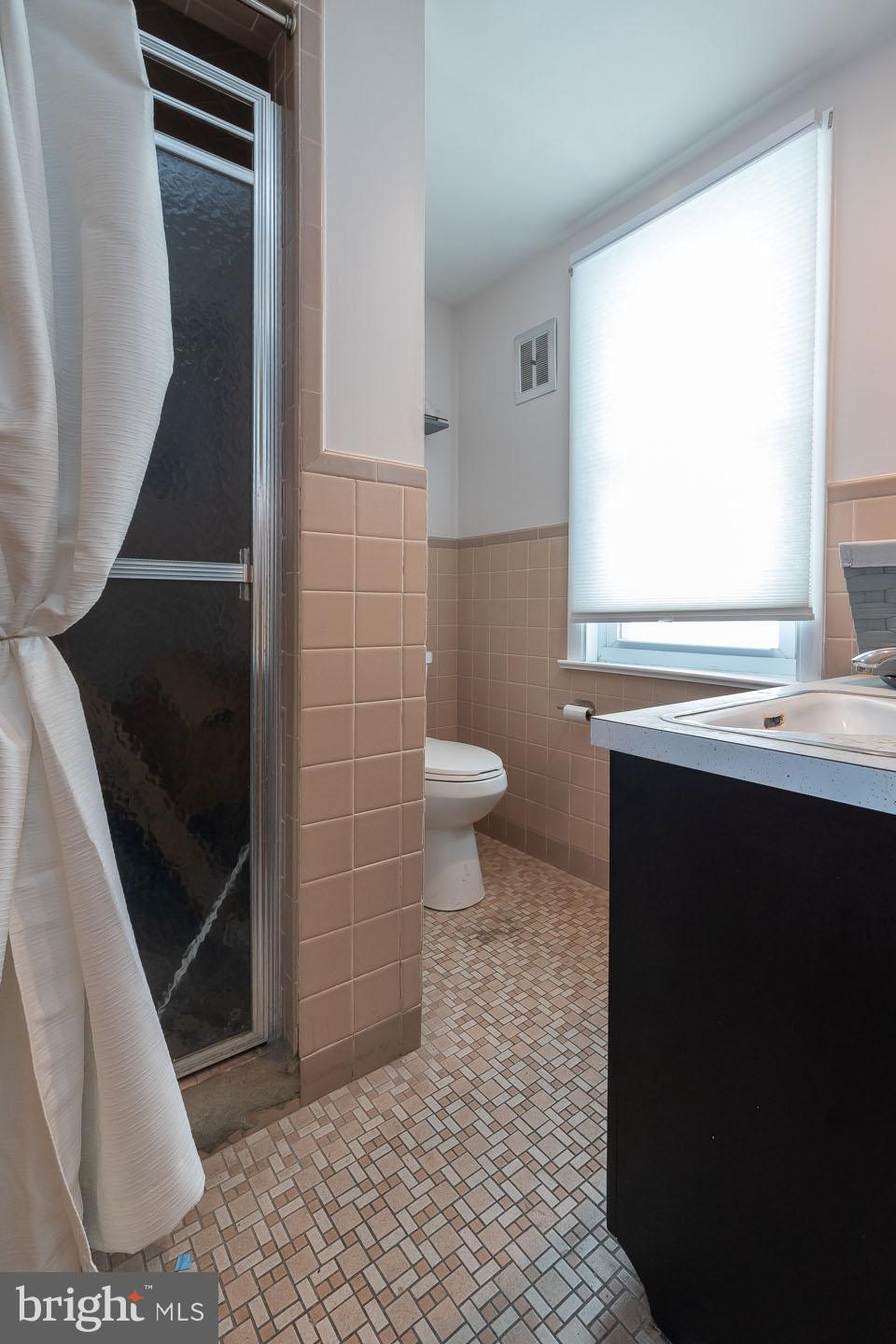 1017 Market Street Gloucester City, NJ 08030 - Photo 21 of 40 a bathroom with a sink a toilet and a mirror