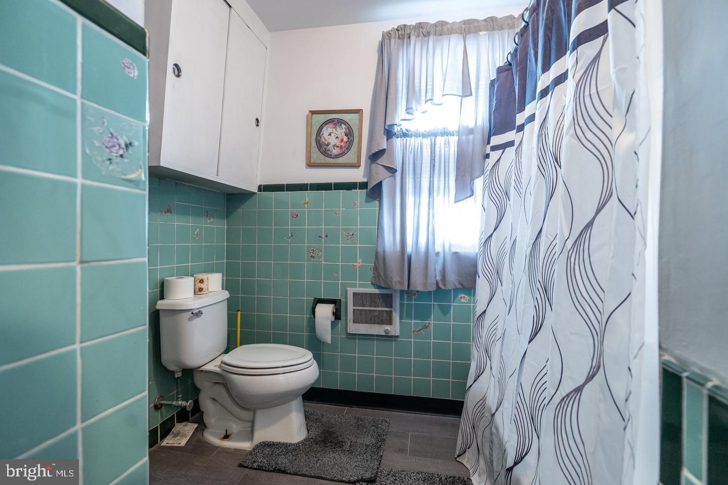 1017 Market Street Gloucester City, NJ 08030 - Photo 27 of 40 a bathroom with a toilet and a shower curtain