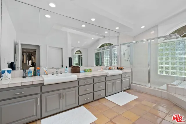 a spacious bathroom with a double vanity sink mirror and bathtub