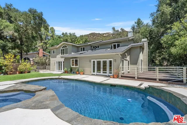 a view of house with yard and outdoor seating