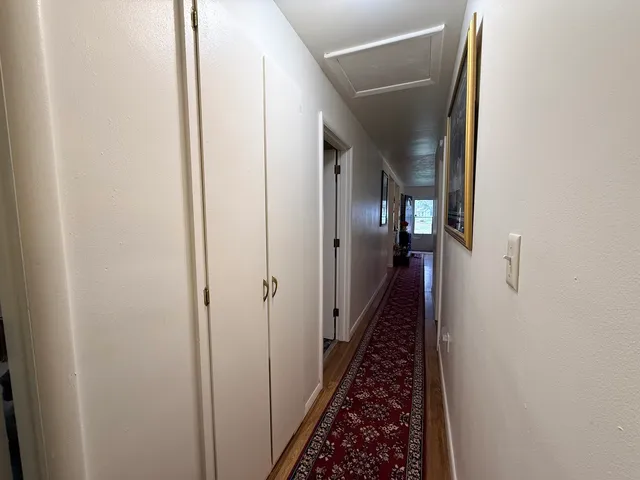 a view of a hallway with wooden floor and staircase