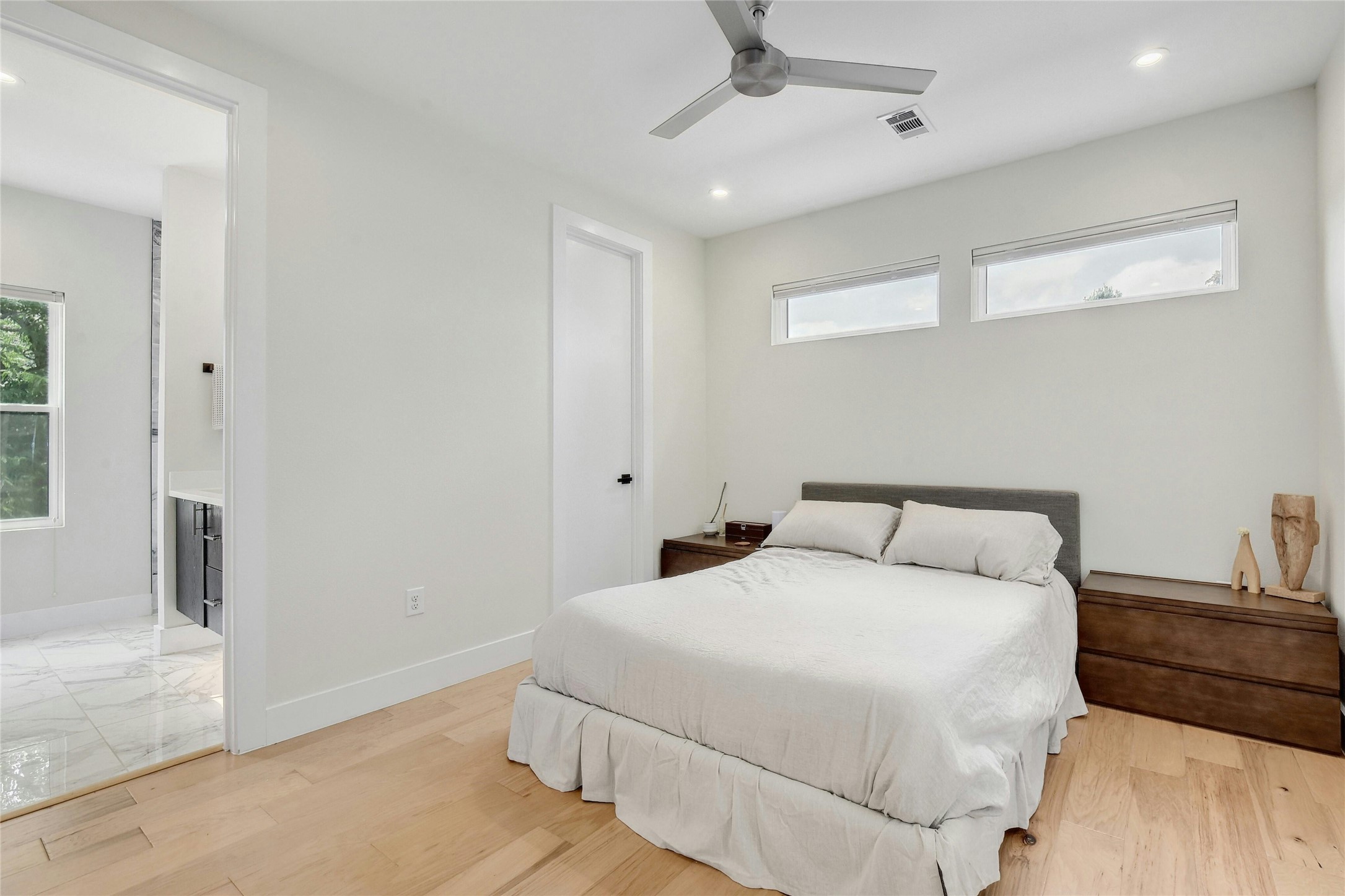 4606 Ledesma Road, Unit 2 Austin, TX 78721 - Photo 16 of 33 Hardwood floors and a subtle ceiling fan create a serene bedroom atmosphere with abundant natural light.