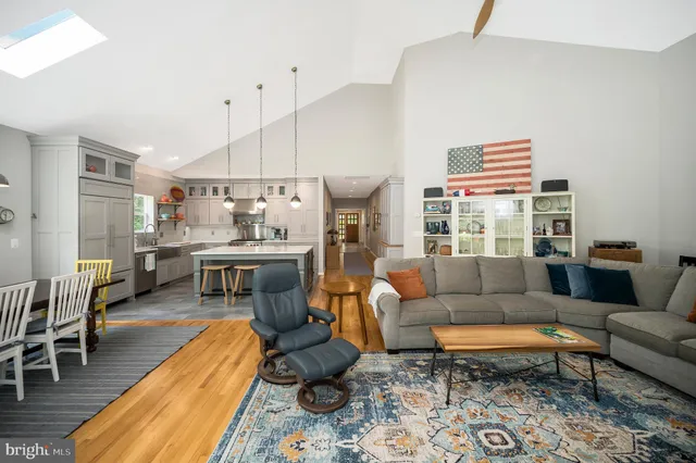 a kitchen with stainless steel appliances kitchen island wooden floor and refrigerator