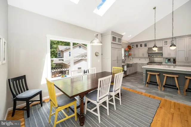 a kitchen with a stove a sink a center island and wooden floor