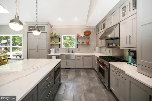 a kitchen with a refrigerator a stove and a dining table with wooden floor