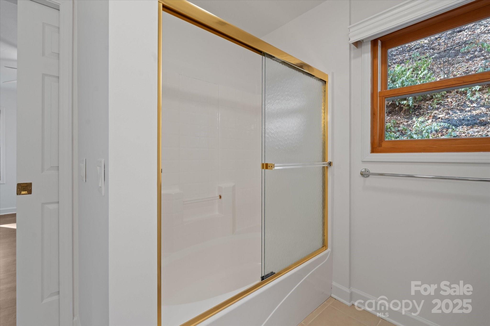 905 Old Fiddle Road Waynesville, NC 28786 - Photo 16 of 39 a bathroom with a glass shower door