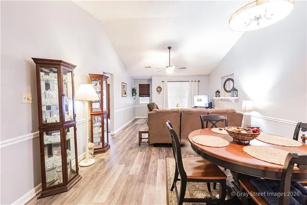 a view of a dining room with furniture a rug and wooden floor