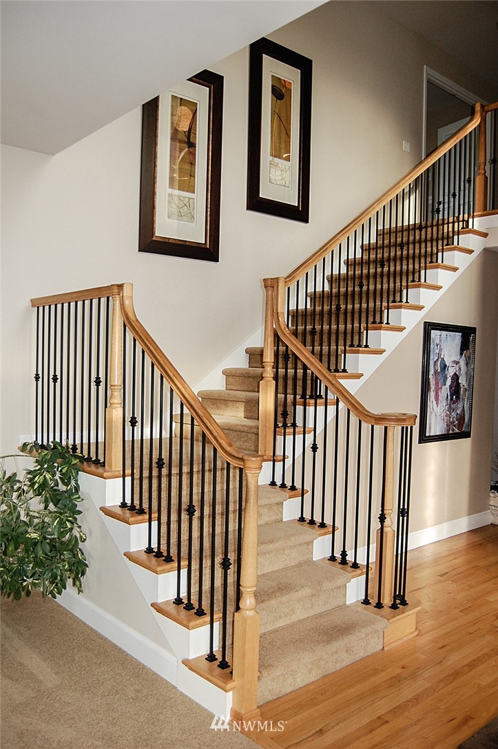 3723 207th Place Southeast Bothell, WA 98021 - Photo 8 of 15 a view of staircase with lots of frames on wall and wooden floor
