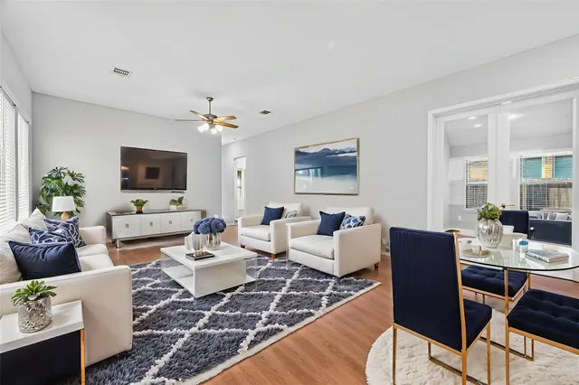 a living room with furniture a large window and a flat screen tv