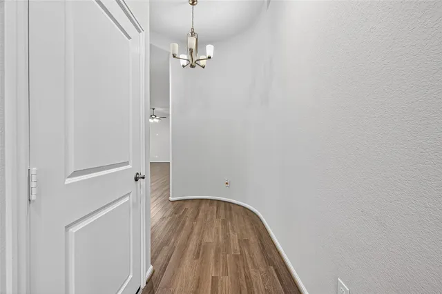 a view of a hallway with wooden floor and closet