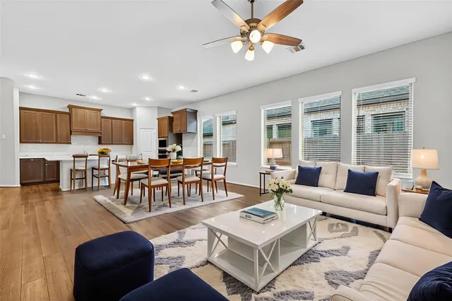 a view of an empty room with a kitchen and wooden floor