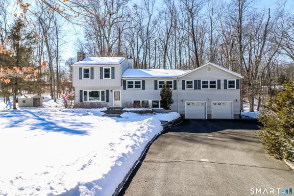 a front view of a house with a yard covered in snow