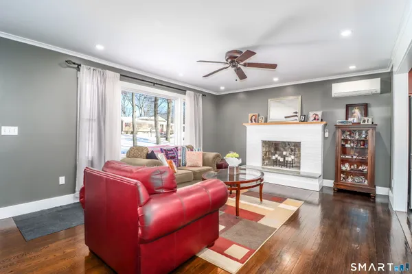 a living room with furniture a wooden floor and a fireplace