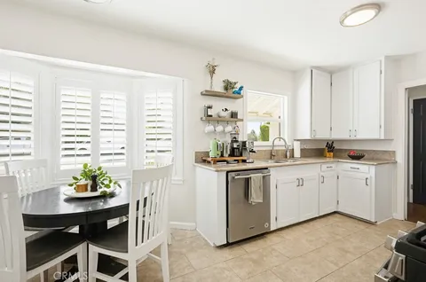 a kitchen with granite countertop white cabinets and white appliances