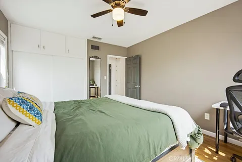 a bedroom with a bed and wooden floor