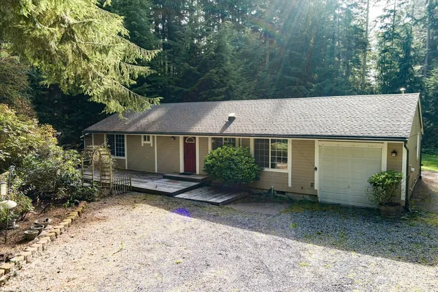 a view of a house with a yard and large tree
