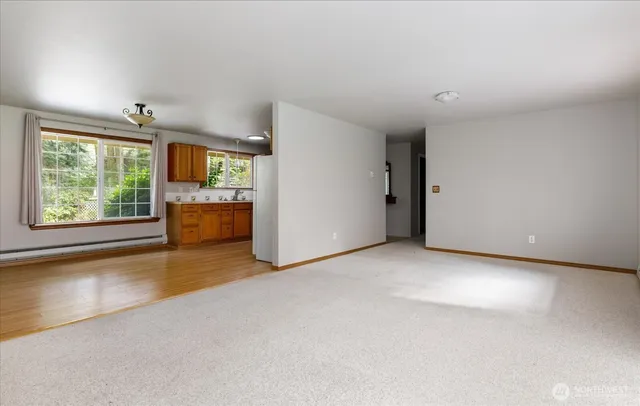 an empty room with windows and cabinet