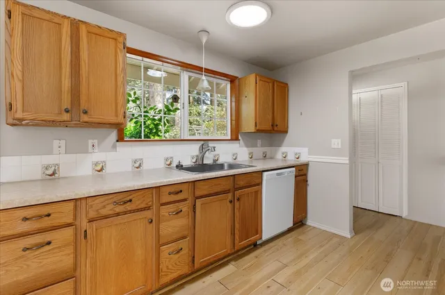 a kitchen with stainless steel appliances granite countertop a sink window and cabinets