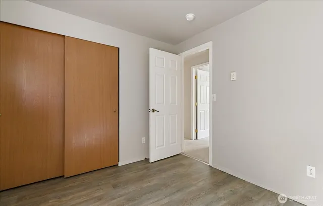 an empty room with wooden floor and closet