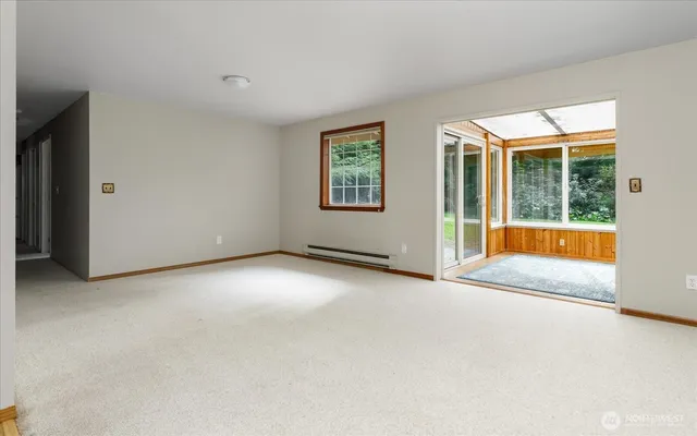 an empty room with a fireplace and large windows