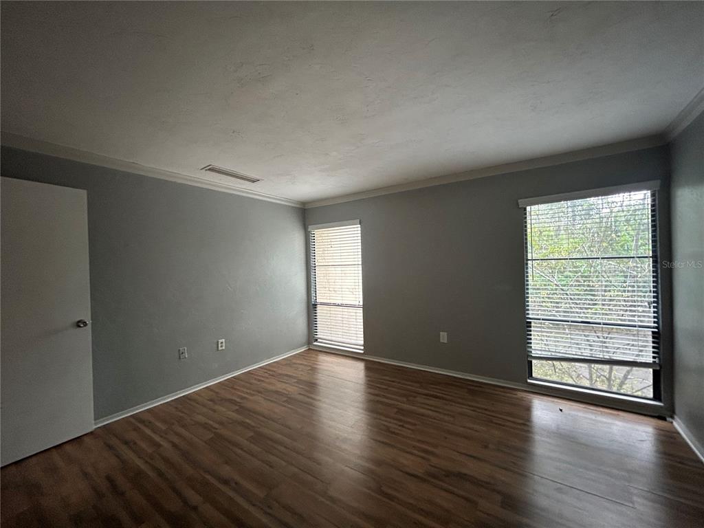 2811 Southwest Archer Road, Unit M106 Gainesville, FL 32608 - Photo 11 of 26 wooden floor in an empty room with a window