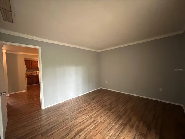 a view of an empty room with wooden floor
