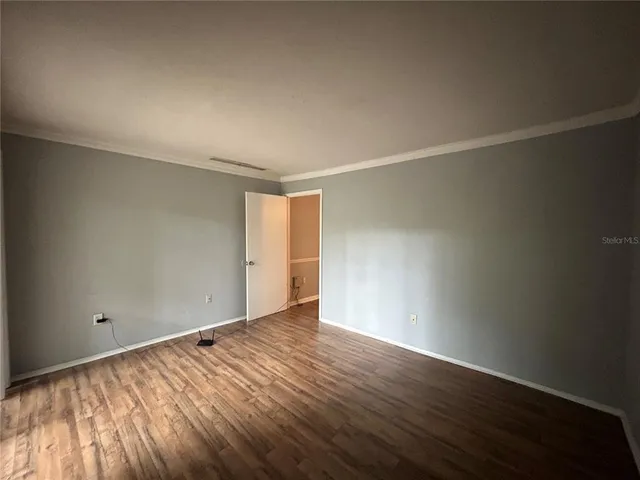 a view of an empty room with wooden floor