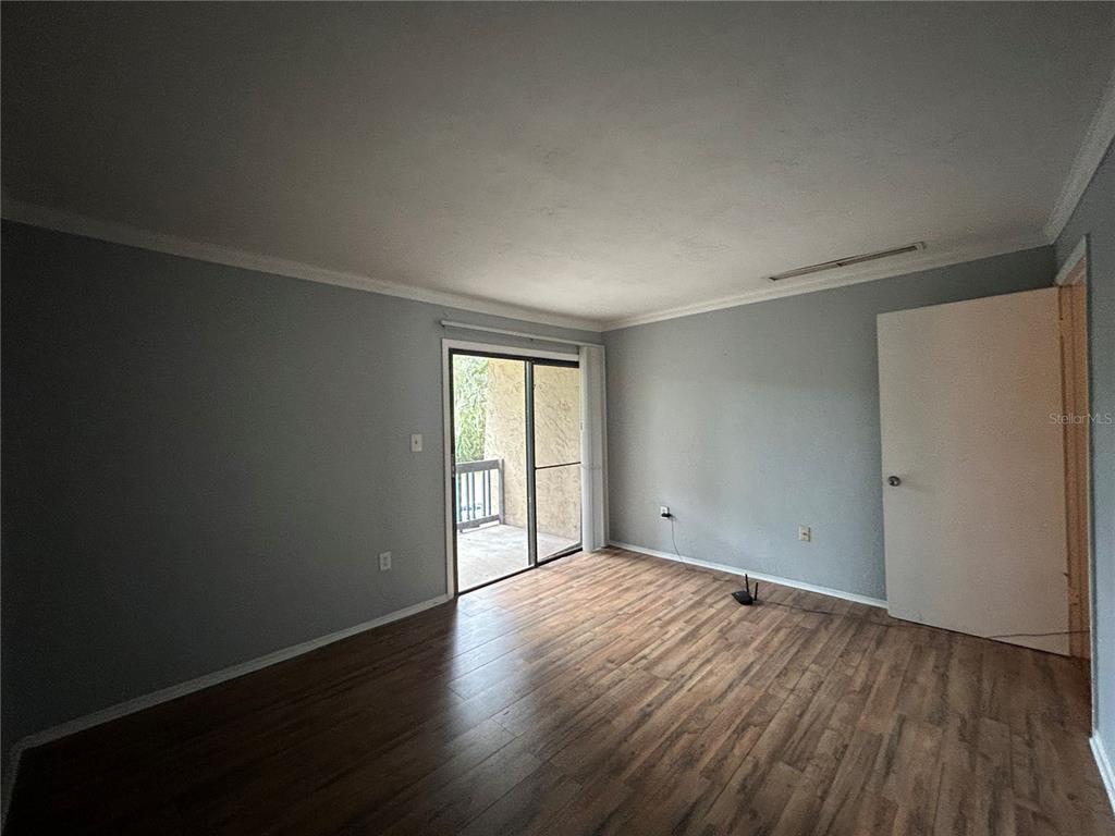 2811 Southwest Archer Road, Unit M106 Gainesville, FL 32608 - Photo 17 of 26 a view of an empty room with wooden floor and a window