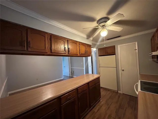 a kitchen with a wooden floor and cabinets
