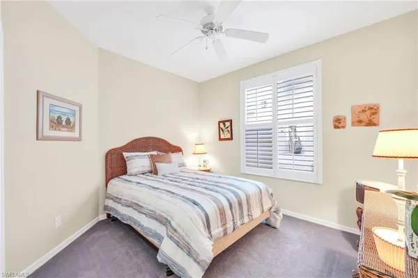 a bedroom with a bed lamp and a large window