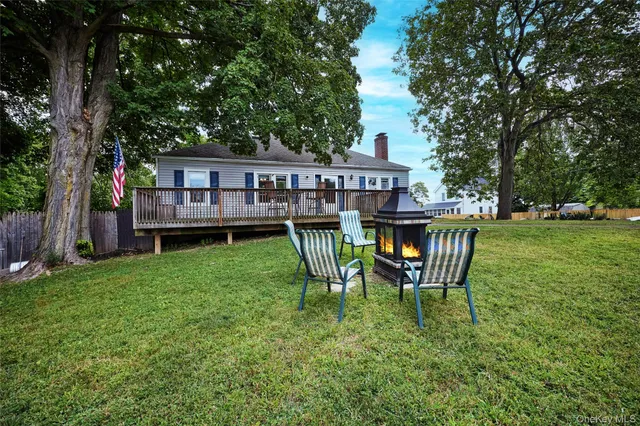 a view of a house with a deck and a yard