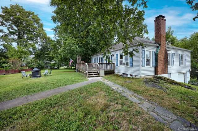 a view of a house with backyard and a tree