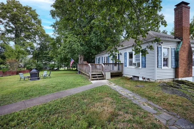 a view of a house with a yard and sitting area