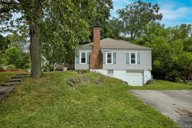 a front view of a house with yard and green space