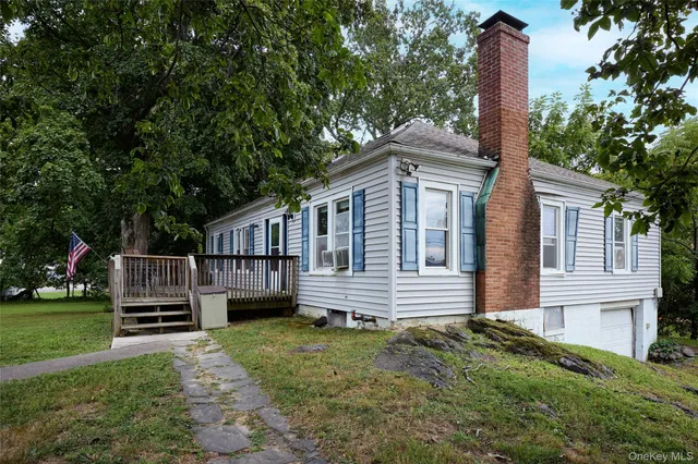 a front view of a house with a garden and trees