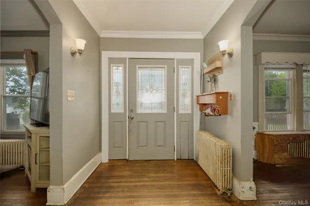 a view of a hallway with wooden floor and a living room