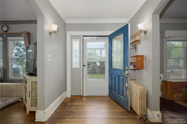 a view of an entryway with wooden floor and a livingroom