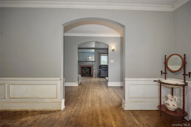 a view of a hallway with wooden floor and cabinet